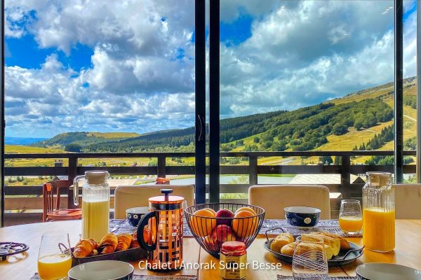 Un petit déjeuner avec une magnifique vue dans la pièce de vie du Chalet l’Anorak à Super Besse